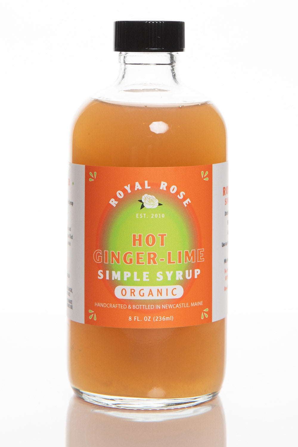 A glass bottle of Royal Rose Hot Ginger Lime Simple Syrup with a black cap and a label that includes the brand name and product description.